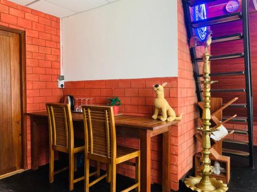 une cuisine avec une table et des chaises en bois dans l'établissement Namunuku mount heaven cabana & resort,passara, à Passara