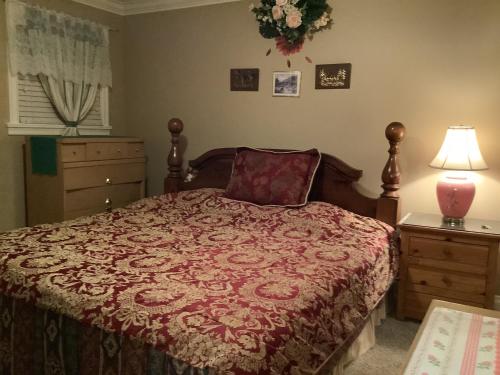 a bedroom with a bed with a red comforter at Barry and Elaine in Abbotsford