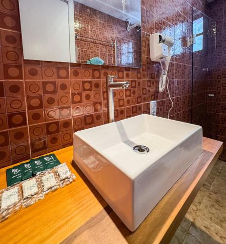 un bagno con un lavandino bianco e uno specchio di Vila Saruê a Búzios