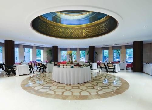 a banquet hall with tables and chairs and a large ceiling at UrCove by HYATT Beijing Forbidden City in Beijing
