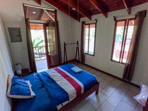 Un dormitorio con una cama en una habitación con ventanas. en Posada Don Javier Mendoza, en Talamanca