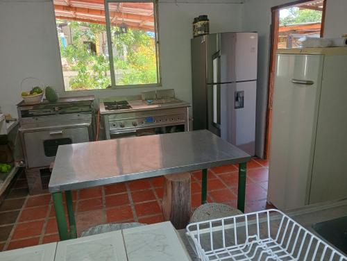 una cocina con una mesa y un refrigerador en Posada La Galilea, en Bochalema