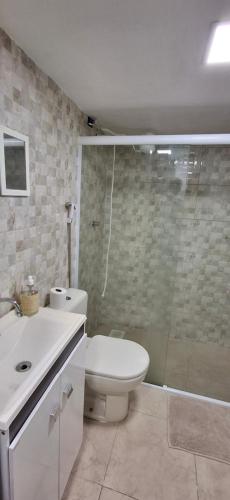 a bathroom with a toilet and a sink and a shower at Shanti House Geribá in Búzios