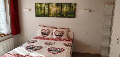 een slaapkamer met een bed met hartkussens erop bij Glorios in Heiden