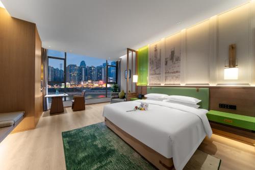 a bedroom with a large white bed and a city skyline at Chongqing Mansion Manyue Hotel in Chongqing