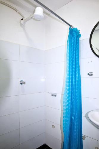 a shower with a blue shower curtain in a bathroom at Hotel Bogota Home in Bogotá