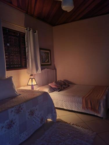 ブエノ・ブランダンにあるChácara Alto do Valeのベッドルーム(ベッド2台、ランプ付)