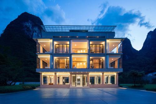 een groot gebouw met een berg op de achtergrond bij Yi Zhan Mountain Homestay in Xingping