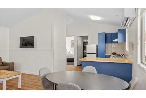 a kitchen and dining room with a table and chairs at Discovery Parks - Woodman Point in Coogee
