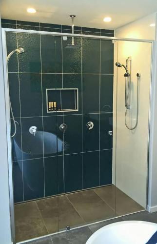 a bathroom with a shower with a glass door at Eastgarth in Venus Bay