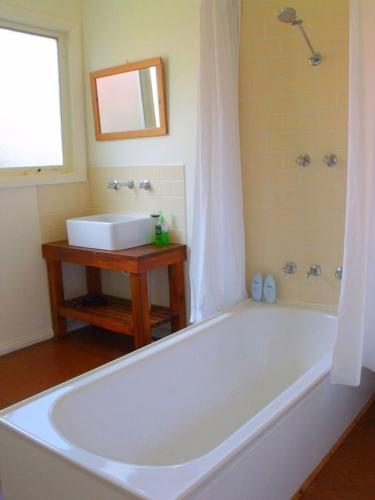 a bathroom with a white tub and a sink at Emada Venus Bay in Venus Bay