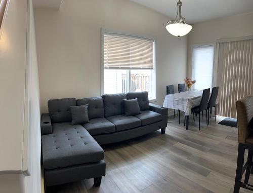 ein Wohnzimmer mit Sofa und Tisch in der Unterkunft Luxurious & Spacious 4-Bedroom Vacation Home in Edmonton