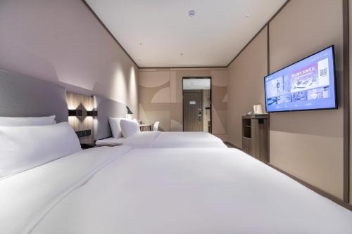 Postel nebo postele na pokoji v ubytování Hanting Hotel Shanghai South Station East China University of Science and Technology