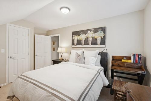 a bedroom with a large white bed and a table at Creekside cutie 3br 2.5ba near skiing sleeps 8 in Kamas