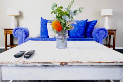 a coffee table with a vase of flowers on it at The Tree House in Long Beach