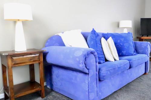 a blue couch in a living room with a side table at The Tree House in Long Beach