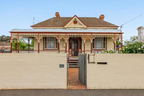 a house with a white fence in front of it at Bendigo Signature Accommodation on Barnard in Bendigo