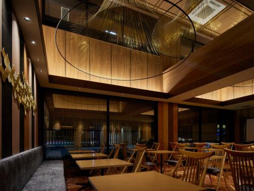 a restaurant with tables and chairs and a ceiling at Minn Kanazawa in Kanazawa
