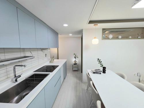 eine Küche mit weißen Schränken und einer Spüle in der Unterkunft 2 Bathrooms & 3 Rooms, New Elevator in Seoul