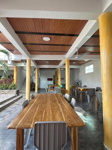 圣玛尔塔Casa Mariana Hostel Boutique的配有椅子的房间里一张大木桌