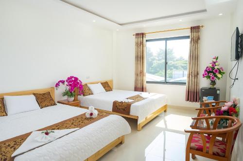 a hotel room with two beds and a window at Hoàng Gia Hotel Sơn La in Sơn La