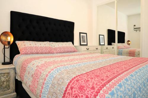 une chambre avec un grand lit et un miroir dans l'établissement Hosts on the Coast All Decked Out, à Whitianga