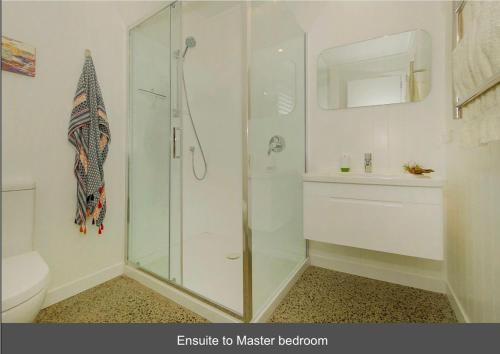 une salle de bains avec douche, toilettes et lavabo dans l'établissement Hosts on the Coast All Decked Out, à Whitianga