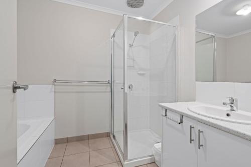 a white bathroom with a shower and a sink at Time to Relax in Portarlington