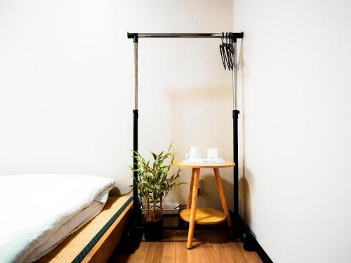 ein Schlafzimmer mit einem Bett und einem kleinen Tisch in der Unterkunft -智 tomo- 難波 天王寺まで約15分 大阪観光に便利な和風宿 無料Wi-Fi in Osaka