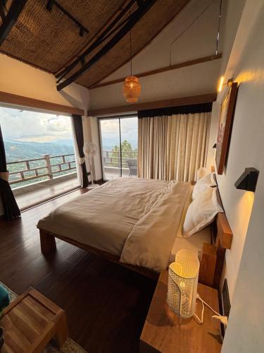 um quarto com uma cama grande e uma janela grande em The Wild Sakura em Mukteswar