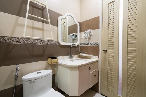 a bathroom with a toilet and a sink and a mirror at Rocky Hotel Ho Chi Minh in Ho Chi Minh City