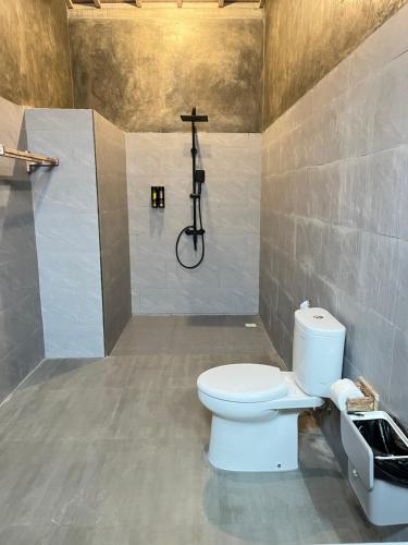 a bathroom with a toilet and a shower at Menjangan Dive Lodge in Banyuwedang