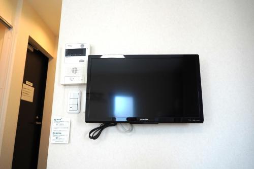 a flat screen tv hanging on a wall at KYU KYU HOTEL in Tokyo
