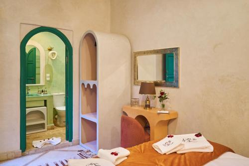 a bedroom with a bed and a mirror and a sink at Riad Lia ou Lik in Marrakesh