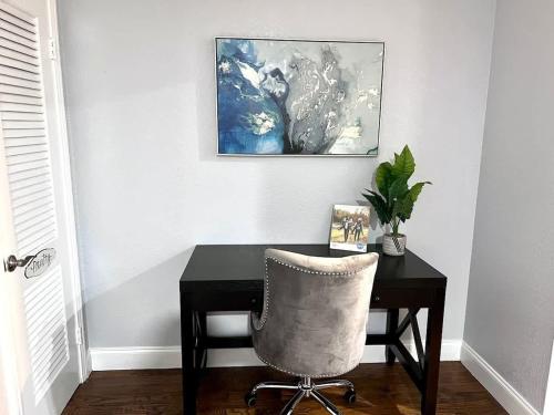 una scrivania con sedia e un dipinto sul muro di Spacious 2BD Condo Grand Prairie GP22B a Heliport-Facility 5A