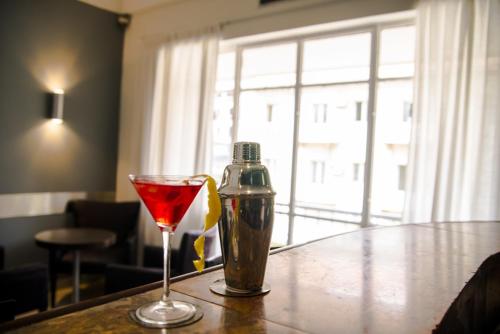 a drink and a bottle on a table at Hotel Continental Luanda in Luanda