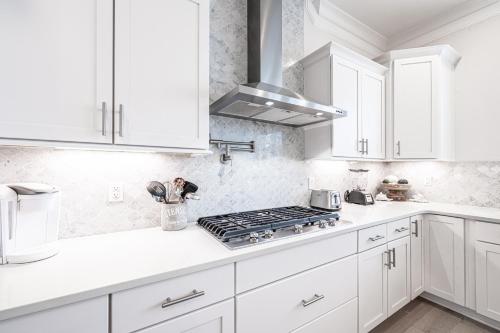 a white kitchen with white cabinets and a stove at Happily Eva After at Prominence 30A in Inlet Beach