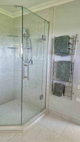 a shower with a glass door in a bathroom at Rosandra Retreat in New Plymouth