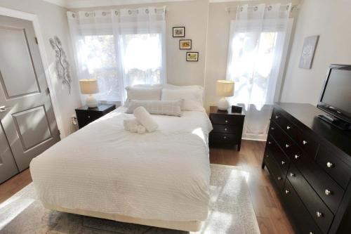 a bedroom with a white bed with two white pillows at The Brightwood House - Family Living in the Heart of DC in Washington