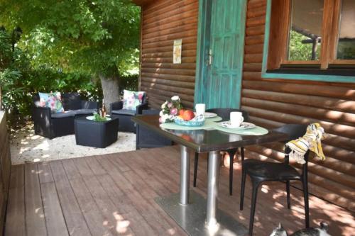 a table and chairs on a porch with a table at ZEcamping 4 étoiles pet friendly piscine et pétanque au cœur des Alpilles in Noves