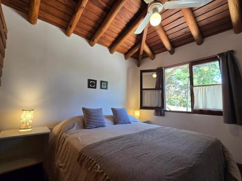 een slaapkamer met een bed met blauwe kussens en een plafond bij Medanos in Las Gaviotas