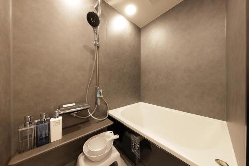 a bathroom with a bath tub and a toilet at The Crane Sanctuary Sapporo in Sapporo
