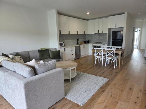 een woonkamer en keuken met een bank en een tafel bij Quiet apartment in Healesville in Healesville