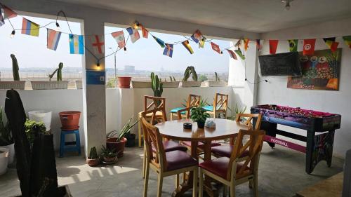 a dining room with a table and chairs and a piano at Jorge Chavez Lima Airport Hostel - FREE AIRPORT PICK UP in Lima