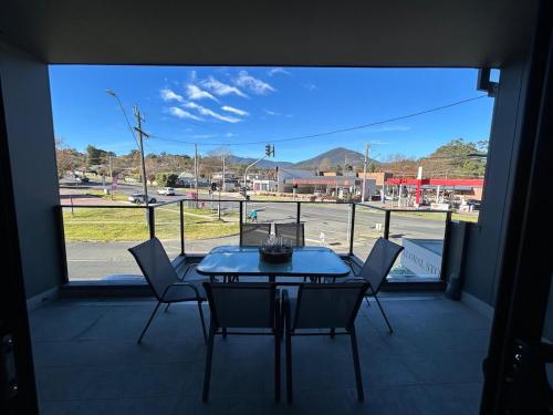 een tafel en stoelen op een balkon met uitzicht op een straat bij Quiet apartment in Healesville in Healesville