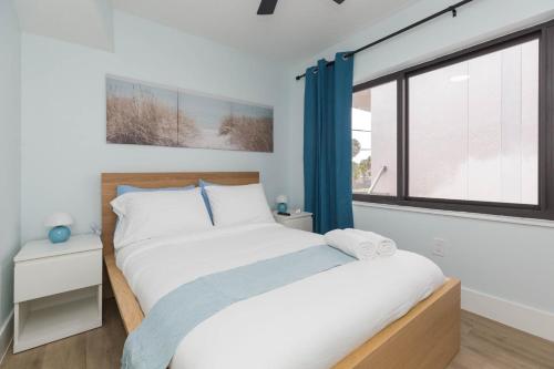 a bedroom with a large bed and a window at Clearwater Bliss Apartment 3 in Clearwater Beach