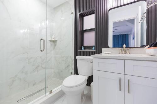a bathroom with a shower and a toilet and a sink at Clearwater Bliss Apartment 3 in Clearwater Beach
