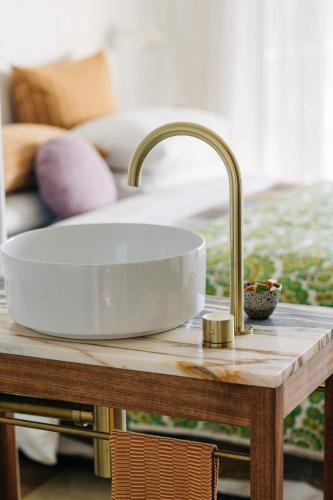 a sink on top of a wooden table next to a couch at Frankie Beach House in Bicheno