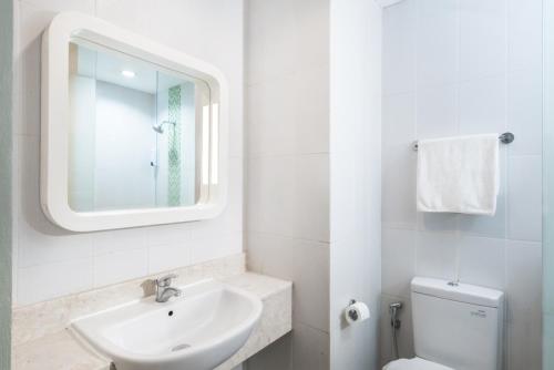 a bathroom with a sink and a toilet and a mirror at Indies Style Malioboro Hotel in Yogyakarta