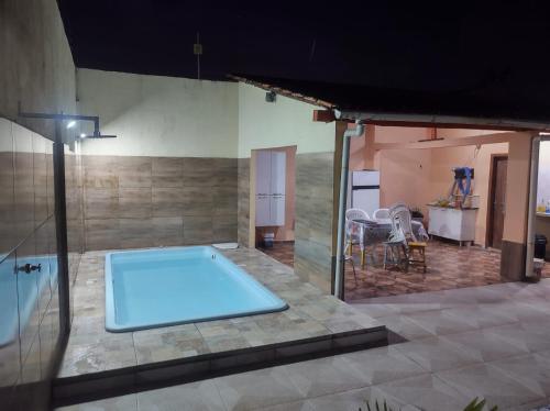 a large pool in a room with a table and chairs at Casa Mosqueiro in Belém
